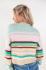 A woman shown from the back wearing a fuzzy knit sweater with horizontal pastel stripes in mint green, pink, teal, beige, and burgundy, paired with blue jeans against a plain white background.