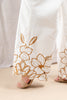 White wide-leg pants with gold floral embroidery along the hem, shown on a model wearing beige flat sandals.
