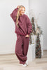 A woman wearing a cozy maroon hooded sweatshirt and matching pants with thin white vertical pinstripes.