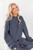 A smiling blonde woman wearing a navy blue and white pinstriped lounge set.