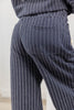 Close-up of a woman wearing navy blue pinstripe lounge pants, showing the back pocket and fabric texture.