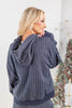 A woman wearing a navy blue and white pinstriped hooded sweatshirt, shown from the back and side. 