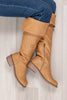 A pair of tan knee-high leather boots with side zippers and elasticated heels, worn with blue jeans on a light wood floor.