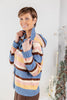 A woman wearing a chunky knit striped cardigan with a hood. The cardigan features horizontal stripes of blue, brown, yellow, and light pink.