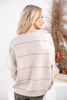 A woman is shown from the back wearing a cream-colored knit sweater with thin horizontal tan stripes.