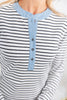 Close-up of a woman wearing a long-sleeve henley top with black and white horizontal stripes and a light blue ribbed collar and placket with dark buttons.