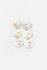 A pair of gold-tone drop earrings featuring a white enamel snowman face design with small black dot eyes and mouth details.