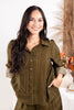 A woman wearing an olive green button-up shirt with a white geometric line pattern.