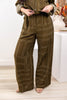 A woman wearing wide-leg olive green pants with a beige geometric line pattern, paired with a matching button-front top.