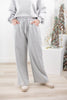A woman wearing light gray wide-leg sweatpants with an elastic waistband and side pockets.