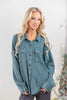 A woman wearing a teal waffle knit button-up shirt with chest pockets.