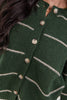 A close up of a woman wearing a green knit cardigan sweater with beige stripes and button front.