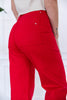 A close-up back view of a woman wearing bright red high-waisted pants with back pockets, paired with a light-colored top.