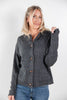 A woman modeling a dark gray knit cardigan sweater with brown toggle buttons, paired with blue jeans, against a plain light gray background.