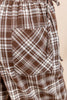 Close-up of brown and white plaid pants showing a front patch pocket and elastic waistband.