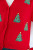 A close-up of a bright red knit cardigan featuring embroidered green Christmas trees with gold stars and red ornaments.