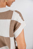 Close-up of a woman wearing a short-sleeve knit top with large taupe and off-white checkered knit panels.