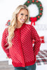 A woman wearing a red button-front cardigan with a white snowflake pattern.