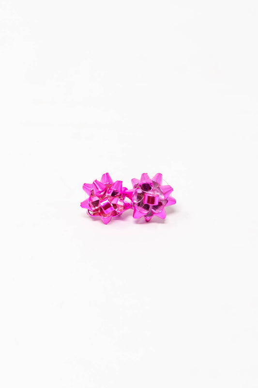 A pair of bright pink metallic stud earrings shaped like a gift bow.