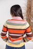 Woman wearing striped cardigan sweater with pink, orange, brown, yellow, and sage green stripes from behind.