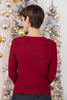 A woman viewed from behind wearing a dark red ribbed knit sweater.