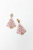 A pair of gold-toned dangle earrings shaped like Christmas trees, decorated with pink enamel, rhinestones, and small star toppers.