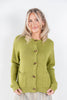 A woman modeling a light olive green knit cardigan sweater with brown toggle buttons, featuring a crew neck, front pockets, and ribbed cuffs and hem, set against a plain white studio background.