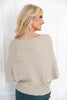 A woman shown from the back wearing a textured, ribbed knit sweater in a light beige color.