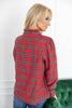 A woman wearing a red plaid long-sleeve shirt with blue jeans, shown from a three-quarters back view.