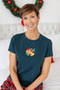 A woman wearing a dark teal crewneck t-shirt with a small embroidered Christmas bell and holly graphic on the chest, paired with red plaid pajama pants.