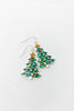A pair of silver-toned dangle earrings shaped like Christmas trees, decorated with green enamel, colorful round ornaments, and gold star toppers.