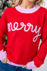 A close-up of a woman wearing a bright red knit sweater with 'merry' written across the chest in light pink script, with matching light pink ribbed collar, cuffs, and hem, paired with blue jeans.