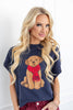 A woman wearing a navy blue knit sweater with a knitted golden retriever dog wearing a red scarf.