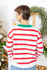 A woman viewed from behind wearing a white knit sweater with bold red horizontal stripes and a green crew neck.