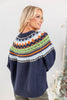 Woman wearing navy blue knit sweater with a colorful Fair Isle yoke pattern in green, orange, white, and blue from behind.