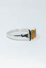 A silver bracelet featuring a witch hat and orange pumpkin topper with small purple and yellow accents, set against a plain white background.
