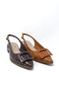A pair of pointed-toe slingback flats on a white background, featuring one dark brown crocodile-embossed shoe and one tan crocodile-embossed shoe, both with a square buckle detail on the toe.