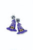 A pair of Halloween-themed dangle earrings featuring purple witch hats with silver glitter details, black belts, and small silver spider charms at the top, shown on a plain white background.