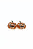 A pair of pumpkin-shaped stud earrings with orange glitter enamel, carved jack-o'-lantern faces, and small green stems, shown on a plain white background.