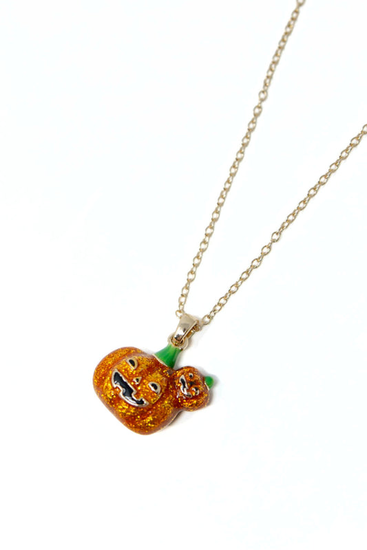 A gold chain necklace featuring a glittery orange pumpkin pendant with a carved jack-o'-lantern face and a small matching pumpkin charm, shown on a plain white background.