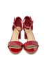 A pair of glossy red patent leather block-heel sandals with ankle straps and open toes, shown from a front-facing perspective on a white background.