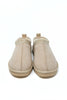 A pair of beige suede slip-on slippers with a decorative lace-up detail around the collar, shown from a top-down view on a white background.